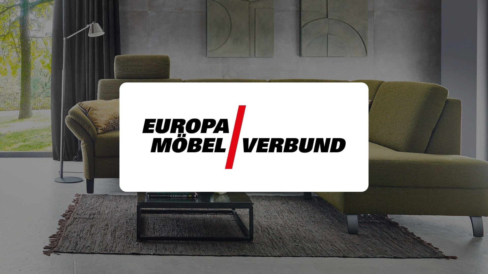 Logo der Europa Möbel-Verbundgruppe vor einer modernen Wohnzimmer-Einrichtung